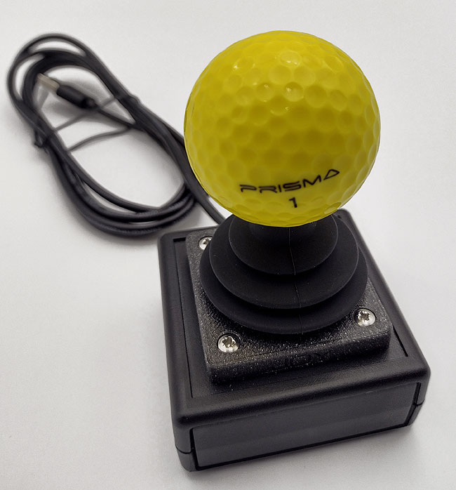 Close up of yellow golf ball top, on small OneSwitch wheelchair style joystick.