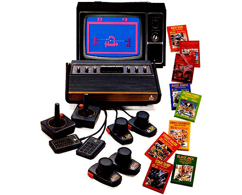 Image of an Atari VCS c. 1977/78 surrounded by  game boxes and game controllers.