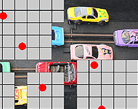 Mix of grey square and parts of a revealed photo of some colourful toy cars on a slot-racing track.